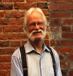 A headshot of a man in a suspenders